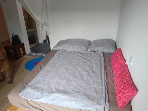 a bed with two pillows and a bed frame in a room at Guest room with private shower and toilet near Salzburg City in Kuchl