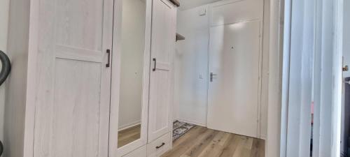 Elle comprend un placard blanc avec des placards blancs et du parquet. dans l'établissement Ostsee-Ferienpark, à Heiligenhafen