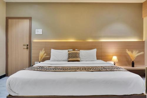 a bedroom with a large bed with a pillow on it at Hotel Sayba Classic in Pandharpur