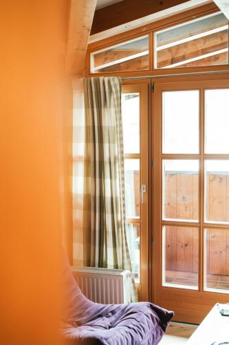 a bedroom with a window and a bed in front of it at Hotel Glemmtalerhof in Saalbach Hinterglemm