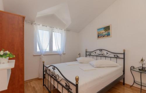 a bedroom with a bed with white sheets and a window at Villa Sestic-Makarska by Villas Guide in Tučepi