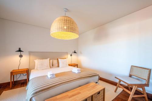 TorreにあるGuestReady - Sunny comfort with a balcony and poolの大きなベッドと椅子のある寝室