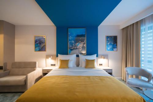 a hotel room with a bed and a couch at Hotel Spa Olive in Mostar
