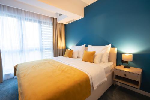 a bedroom with a large bed with a blue wall at Hotel Spa Olive in Mostar