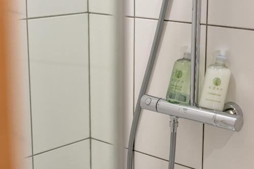 a towel rack with two bottles of soap on a wall at Garden Neuk - Waid Terrace No 26 in Anstruther