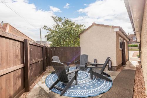a patio with chairs and a table and a fence at Garden Neuk - Waid Terrace No 26 in Anstruther