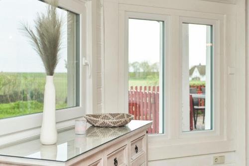 a white vase sitting on a counter with a window at Horn sien Hus in Simonsberg
