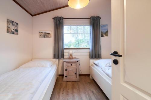 a bedroom with two beds and a window at Horn sien Hus in Simonsberg