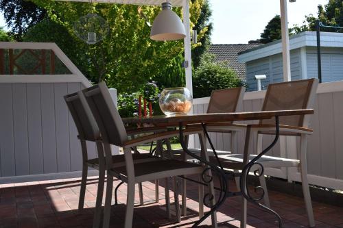 a wooden table and chairs on a patio at Ferienwohnung Am Moorweg in Ihlow