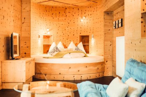 a bedroom with a bed in a wooden room at Hotel Glemmtalerhof in Saalbach Hinterglemm