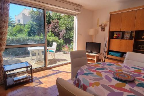 un salon avec un lit et une grande fenêtre dans l'établissement Apartment with garden - near beach, à Fréjus