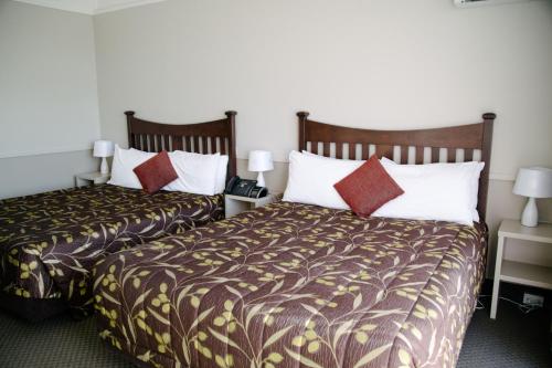 two beds sitting next to each other in a hotel room at Hotel Ashburton in Ashburton