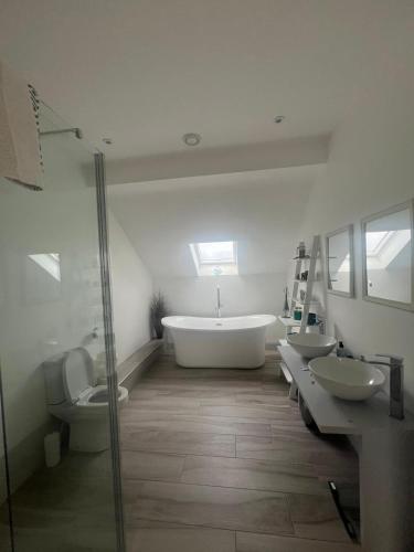 a bathroom with two sinks and a tub and two toilets at Unique Home with Outdoor Sauna in Connemara in Galway