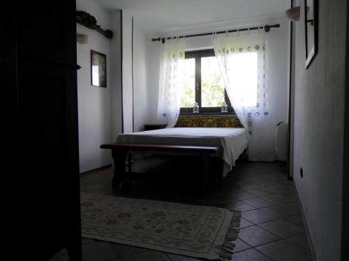 a bedroom with a bed and a window at Ciabòt Taricchi in Dogliani