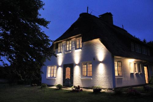 a white house with lights on it at night at Haus Westerheide in Nieblum