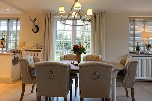 une salle à manger avec une table et des chaises en bois dans l'établissement Haus Windrose, à Wrixum