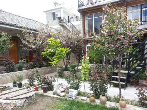 a garden with trees and plants in front of a house at Kevin's Trekker Inn in Shangri-La