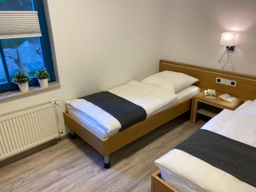 a small room with two beds and a window at Familienfreundliches Reetdachhaus Weissdorn 2 in Puddemin