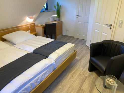 a bedroom with a bed and a chair and a desk at Familienfreundliches Reetdachhaus Weissdorn 2 in Puddemin
