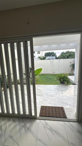 a sliding glass door with a view of a yard at Dahlia Home - Maison entière - 4 Chambres in Komé