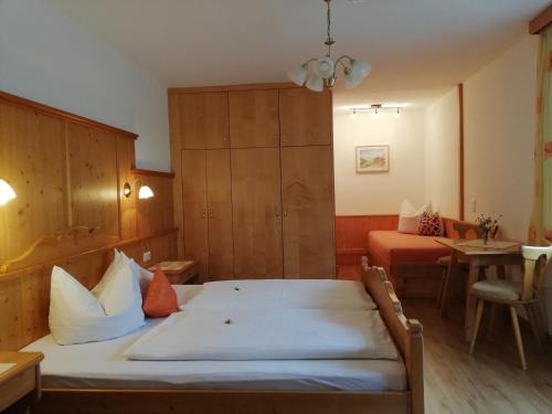 a small room with a bed and a table at Gästehaus Sonja in Niederau
