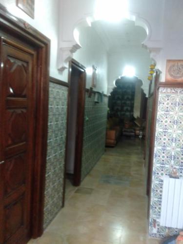 a hallway with green tiled walls and a hallway with a door at Dar Zakia in Tunis
