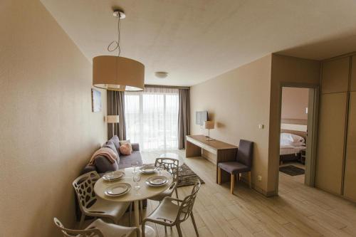 a living room with a couch and a table with chairs at VacationClub - BORMIO Apartament 17 in Sienna