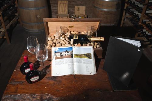 a table with wine bottles and a book and wine glasses at Hotel Francia in Tandil