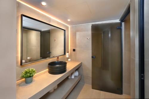 a bathroom with a sink and a mirror at Anmaria Beach Hotel & Spa in Ayia Napa