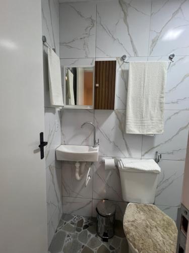 een witte badkamer met een wastafel en een toilet bij Manaira Suite 03 com 2 camas de solteiro ou 1 de casal in João Pessoa