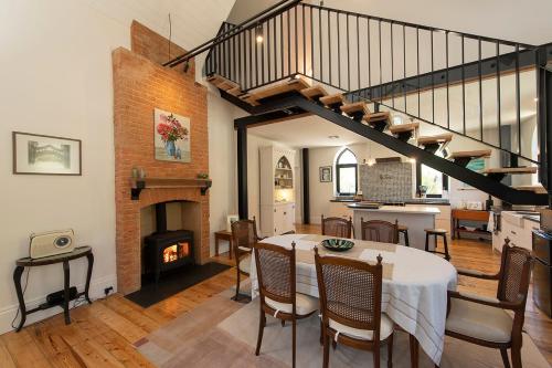 a living room with a table and a fireplace at The Old School Historic Stay for 2 Adelaide Hills in Balhannah
