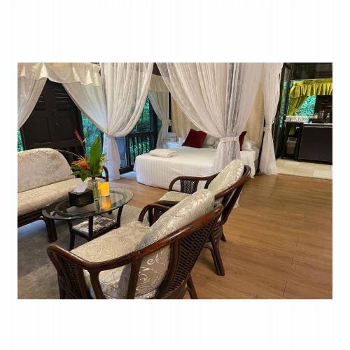a bedroom with a bed and a table and chairs at Villa Sri Kampung in Kuah