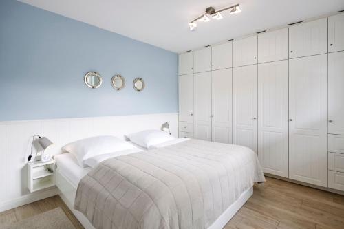 a white bedroom with white cabinets and a bed at Wiesenglück in Wyk auf Föhr