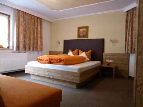 a bedroom with a bed with orange pillows at Apart Heidi in See