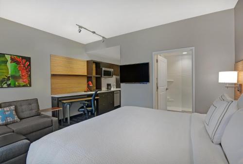a bedroom with a bed and a couch and a desk at TownePlace Suites by Marriott Sarasota/Bradenton West in Bradenton