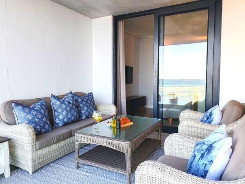 a living room with a couch and chairs and a table at Wavescapes Hang Ten Stay in Cape Town