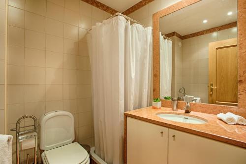 ein Badezimmer mit einem WC, einem Waschbecken und einem Spiegel in der Unterkunft BmyGuest - Arroios Lisbon Apartment in Lissabon