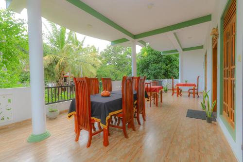 a dining room with a table and chairs on a porch at Castle Resort Yala in Tissamaharama
