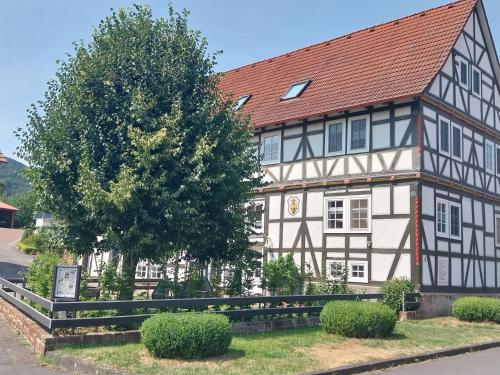 a white and black building with a red roof at Ferienwohnung "Zum Alten Römer" in Kleinern