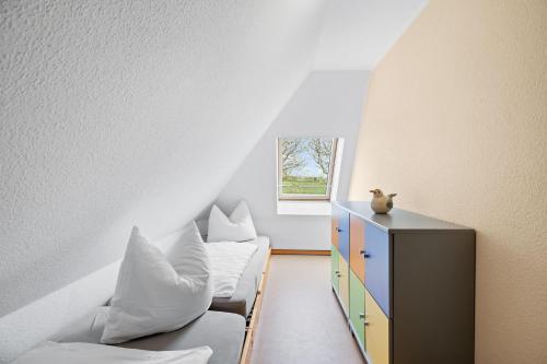 a room with a couch and a dresser with pillows at Ferienhof am Leuchtturm mit Meerbl in Kägsdorf