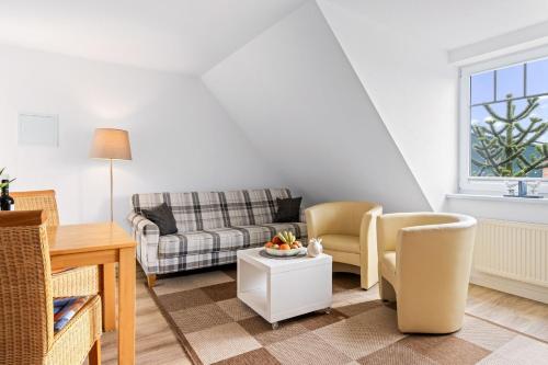 a living room with a couch and a table at Ferienhof am Leuchtturm mit Meerbl in Kägsdorf