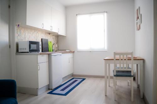 a small kitchen with a table and a microwave at Riad'a Praia in Armação de Pêra