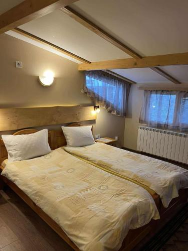 a bedroom with a large bed with white sheets at Hotel Four Seasons in Samokov