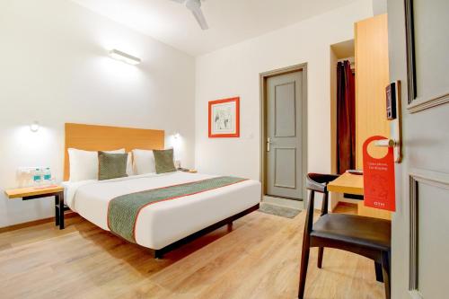 a hotel room with a bed and a desk at Townhouse Surajkund in Faridabad