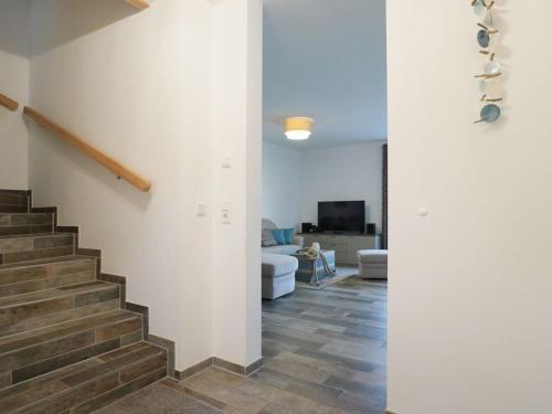 a hallway with a staircase and a living room at Schatzkiste Reetdachhaus in Tarnewitz