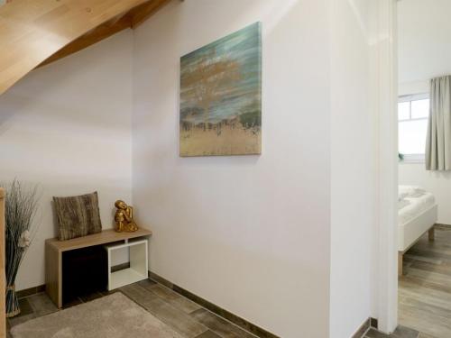 a room with a white wall with a painting on the wall at Schatzkiste Reetdachhaus in Tarnewitz
