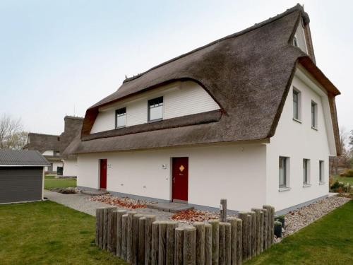 a white house with a thatched roof at Schatzkiste Reetdachhaus in Tarnewitz