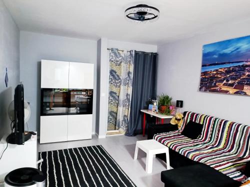 a living room with a couch and a tv at Ocean view 2 bedroom flat in Setúbal