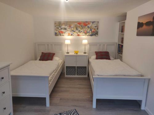 a bedroom with two beds and a painting on the wall at Ferienhaus Salamander inkl Sauna in Wildemann