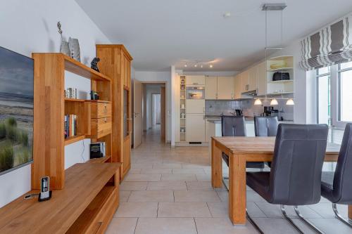 a kitchen with a wooden table and chairs at Schloss am Meer 9 in Wyk auf Föhr